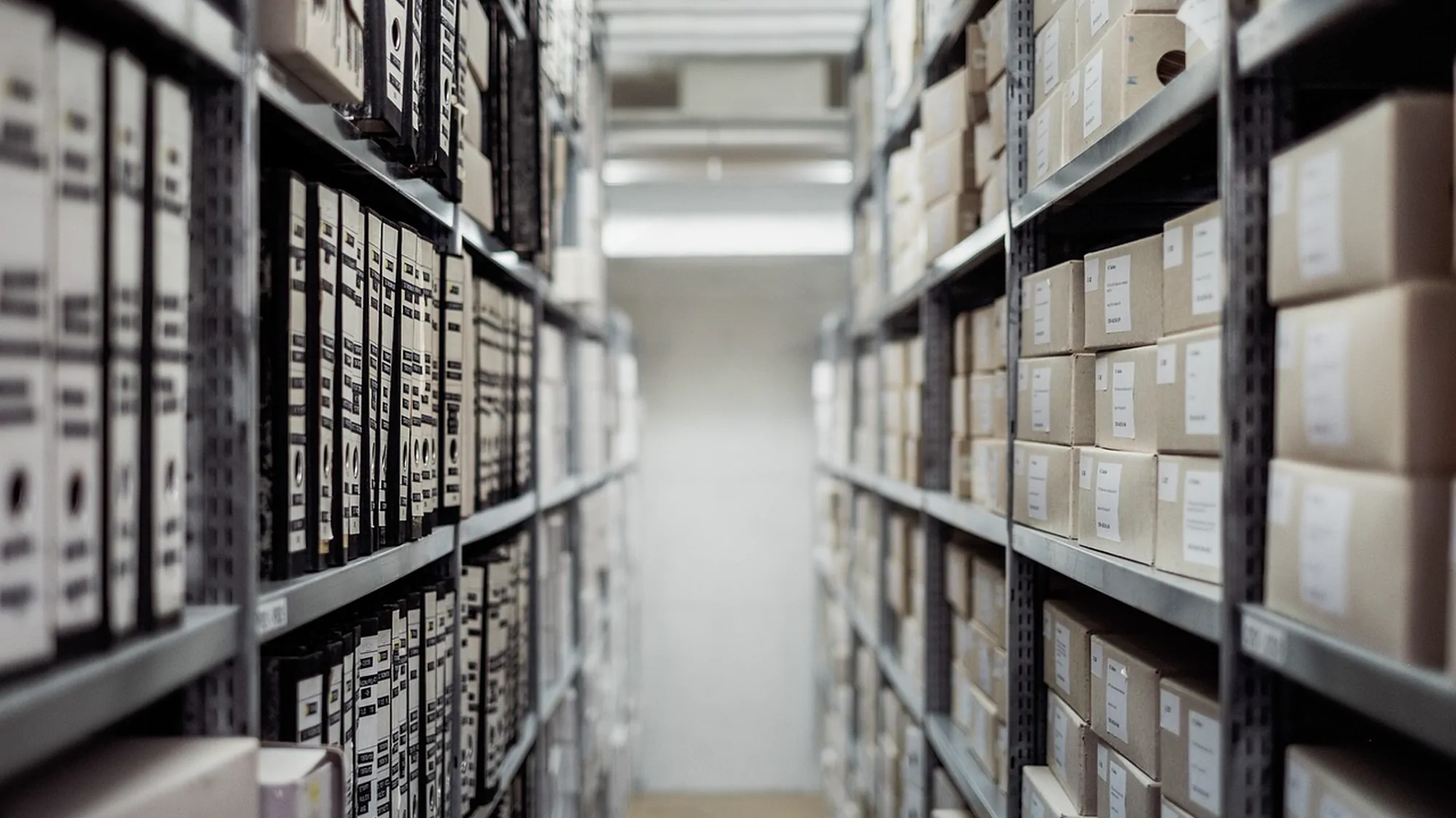 A long archive aisle lined with labelled document boxes
